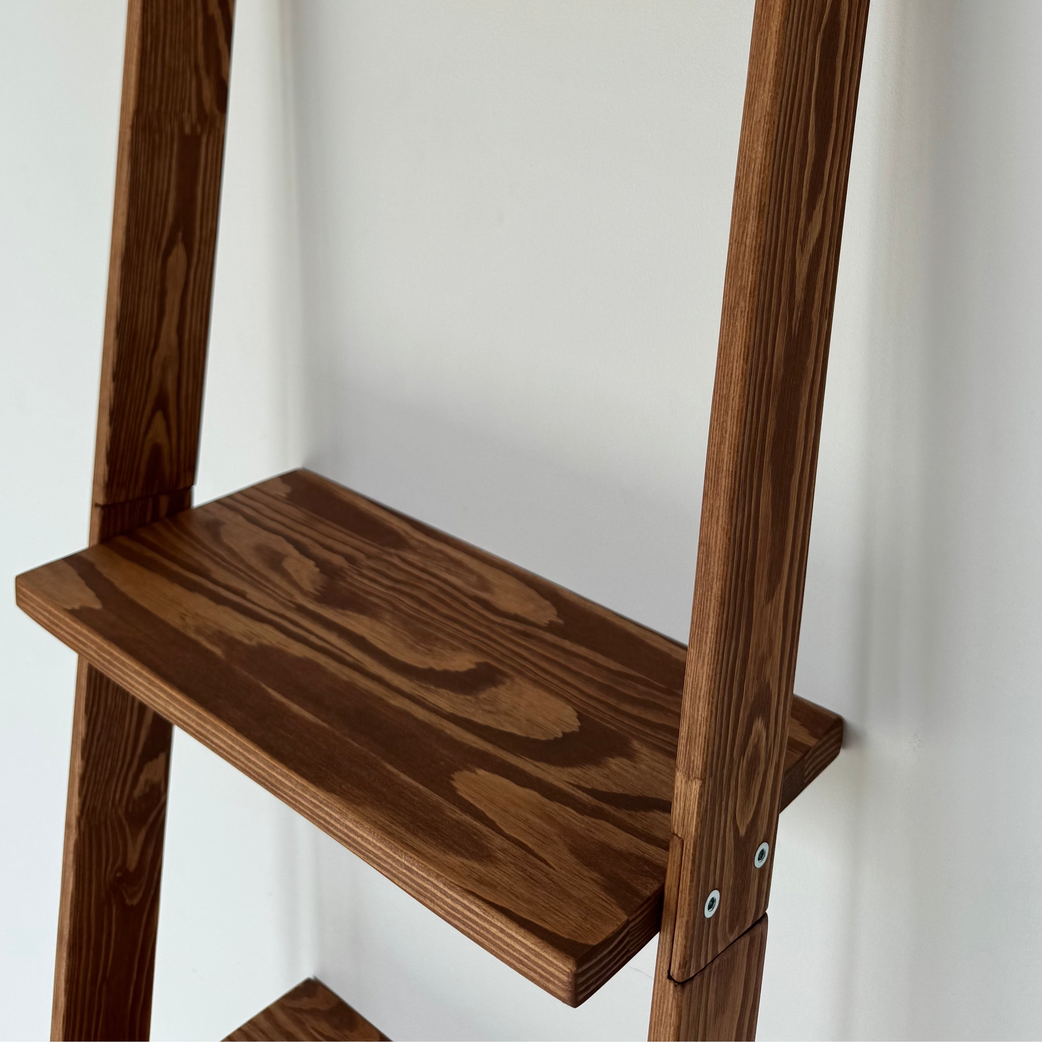 Wooden step ladder against a white wall